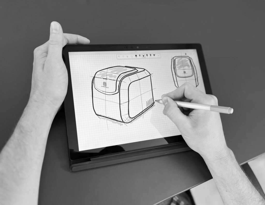 Over the shoulder view of a person drawing an industrial design sketch on a tablet.